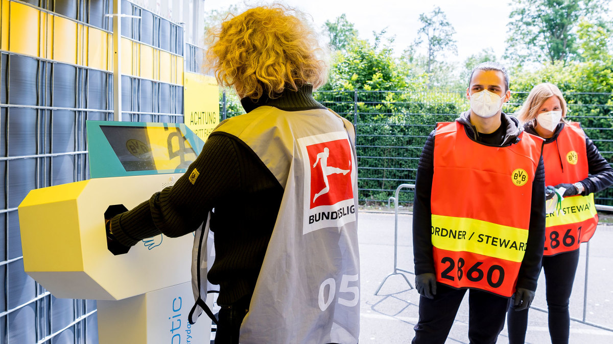 Stadium stewards sanitize their hands before Dortmund vs. Schalke